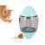 Cat playing with interactive treat dispensing toy, egg shaped, clear plastic with green lid, cat is orange and white