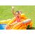 Girl sliding down the Intex Dinosaur Play Center inflatable water slide with hands up