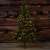 180 cm tall artificial Christmas tree with built-in LED lights, half-tree design, in a rustic setting
