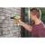 Man using RYOBI R18RPD-0 cordless drill driver to drill into brick wall