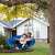 Two children using Pepita nest swing, blue, 100cm diameter, steel frame, Oxford fabric