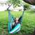 Pepita single hanging chair with cushions, blue and green striped, in use in a garden