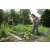 Woman using Gardena combisystem telescopic handle with hoe to weed garden