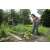 Woman using Gardena combisystem telescopic handle with hoe to weed garden