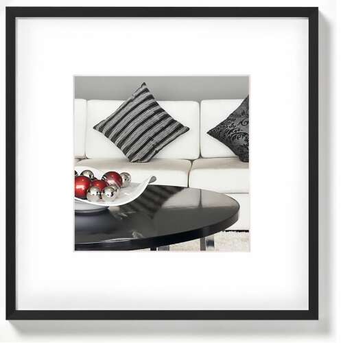 Fekete képkeret fehér paszpartuval, egy nappali jelenettel, kanapéval és kávézóasztal