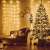 Warm white LED curtain lights decorating a living room with a Christmas tree and a couch