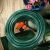 CellFast Economic Garden Hose with Spray Nozzle in Garden Setting