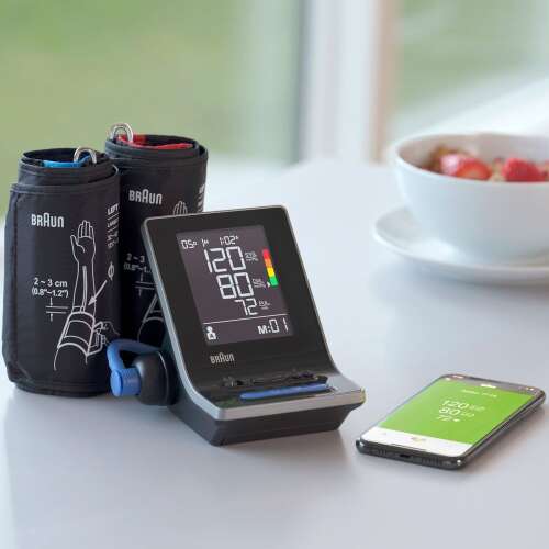 Monitor krvného tlaku Braun ExactFit 5 Connect s Bluetooth konektivitou, zobrazujúci zariadenie, dve manžety a smartfón s aplikáciou Braun Healthy Heart