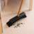 York Econatural broom with bamboo handle, black bristles, sweeping up sunflower seeds