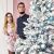 Couple posing with a Christmas tree decorated with pink and blue Springos ornaments