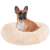 Cream colored Springos donut dog bed with a dog sitting in it