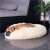 Cream colored Springos donut dog bed with a dog lying in it