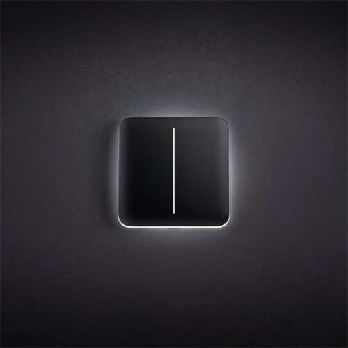 Ajax LightCore smart light switch with illuminated button, mounted on wall
