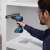 Man using Bosch GSR 185-LI Professional cordless drill driver to install drawer slides