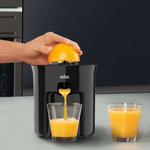 Braun CJ 3050 elektrischer Zitruspresse im Einsatz, Orangensaft wird in ein Glas gepresst