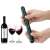 Hand holding a green pneumatic wine opener, with a bottle of wine and two glasses of wine in the background