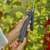 Gardena PowerCut 50 electric pruning shears in use, cutting a branch