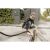 Woman cleaning drain with Karcher WD 2 Plus wet and dry vacuum cleaner