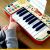 Child's hand playing Djeco Tigris Synthesizer, learning to play music