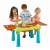 Kids playing with Keter Creative Fun Table, green and red plastic sand and water table for kids, with two compartments, lids, and accessories