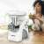Zelmer ZMM9801B electric meat grinder, white, with woman drinking smoothie in the background