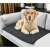 Black quilted dog pee pad on a sofa with a dog lying on it