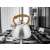 Stainless steel kettle with wooden handle on a stovetop