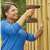 Woman using Black+Decker BDCDD186-QW 18V Cordless Drill Driver to drill into a wooden fence