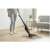 Woman using Sencor SVC 0608BK cordless stick vacuum cleaner on hardwood floor