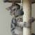 Cat playing with a toy on the Purlov 4 level cat scratching post with a house, grey