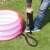 Person using Bestway Air Hammer manual pump to inflate an inflatable pool