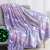 Purple glow in the dark unicorn and stars blanket on a couch, showing the glow in the dark feature