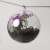 Clear acrylic Christmas ornament filled with artificial flowers and greenery