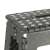 Close-up of the top of a dark grey folding step stool with white dots on the top, the stool is shown from the front